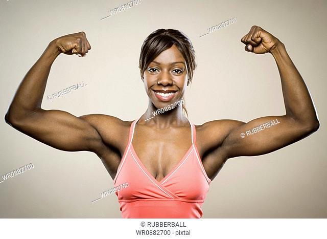 Portrait of a young woman flexing her muscles