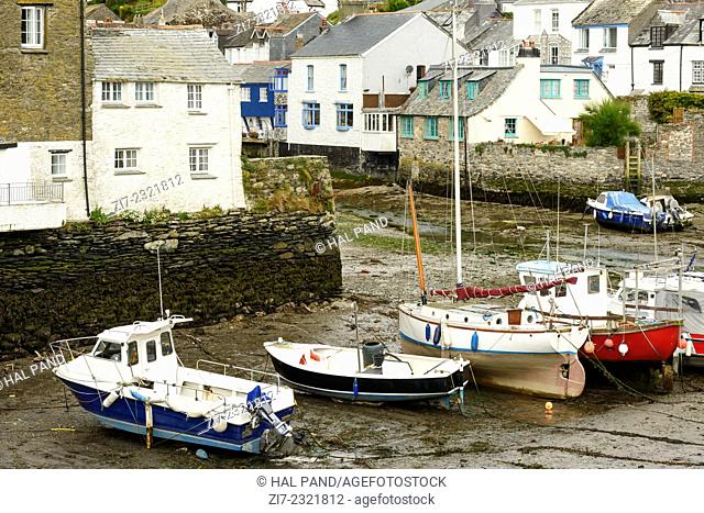 boats in dry harbour, Polperro, cityscape of the touristic village on southern coast of Cornwall with low tide in the river harbour and boats aground