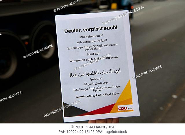 ILLUSTRATION - 24 September 2019, Berlin: A woman is holding a flyer of the CDU-Britz in her hand (recording) with the headline: ""Dealer, fuck off""