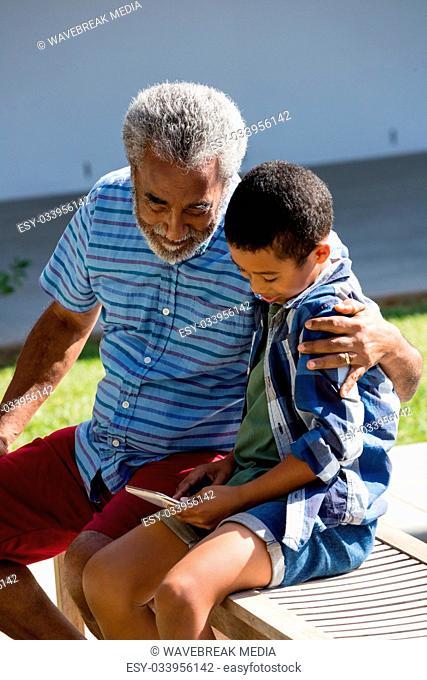 Grandfather and grandson looking at mobile phone