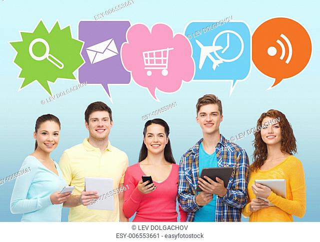 people, communication and technology concept - smiling friends with smartphones and tablet pc computers over blue background with doodles
