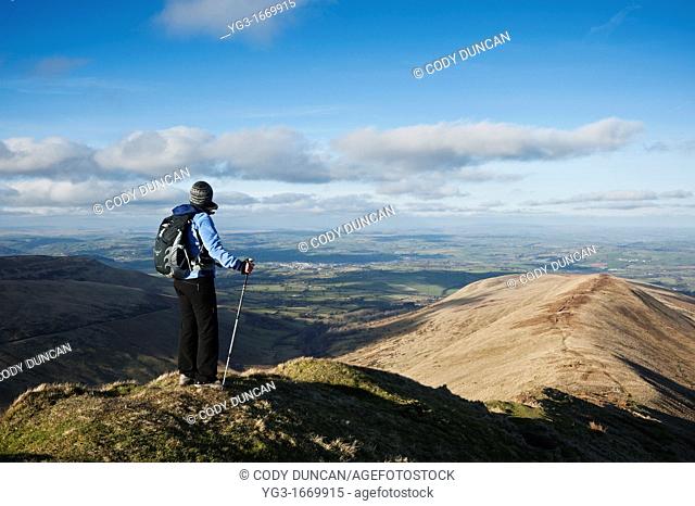 Female hiker enjoys view from Fan Y Big looking towads Brecon, Brecon Beacons national park, Wales