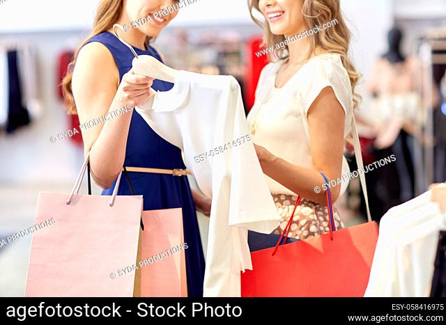 happy women with shopping bags at clothing shop