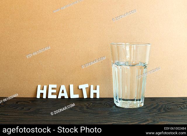 Glass with water on wooden table. brown background. Healthy food, Weight management