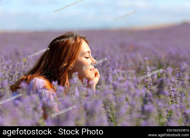 Side view portrait of a woman resting and relaxing in the middle of lavender field