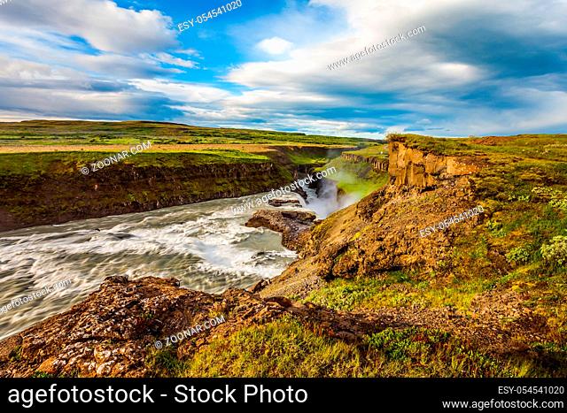 Picturesque multi-colored tundra on a sunny summer day. The waterfall in Iceland - Gullfoss on the Hvitau River. The concept of extreme and phototourism