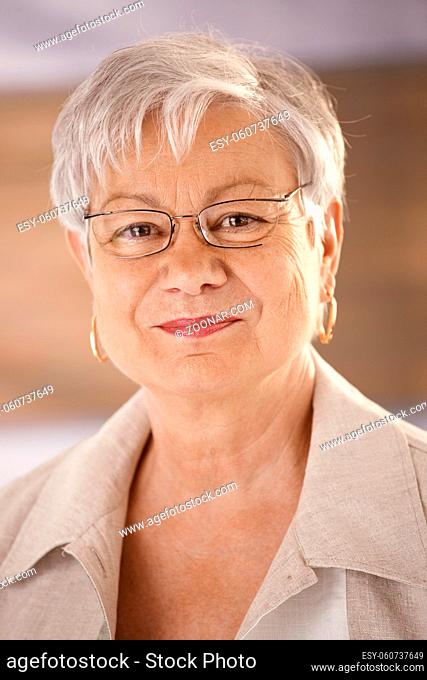 Closeup portrait of happy senior woman wearing glasses, looking at camera, smiling