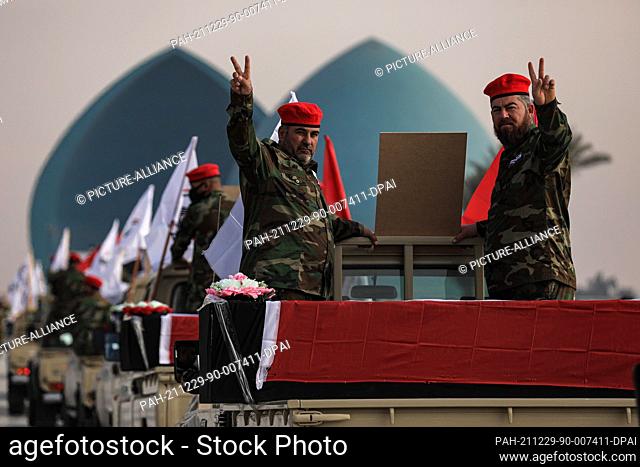 29 December 2021, Iraq, Baghdad: Members of the Iraqi predominantly Shia Muslim Popular Mobilization Forces (PMF) parade symbolic coffins at Baghdad's Tahrir...