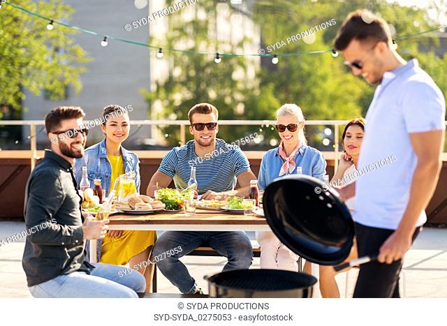 man grilling on bbq at rooftop party