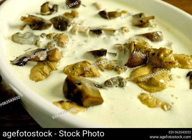 Fried pieces of chicken with mushrooms, in milk in a cup, aromatic lunch