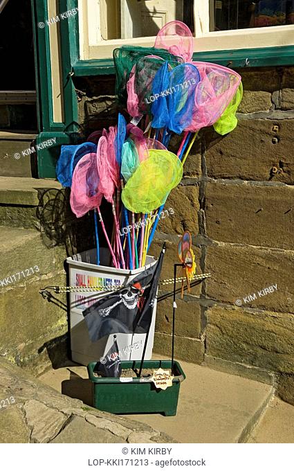 England, North Yorkshire, Robin Hoods Bay. Small childrens fishing nets for sale outside a shop