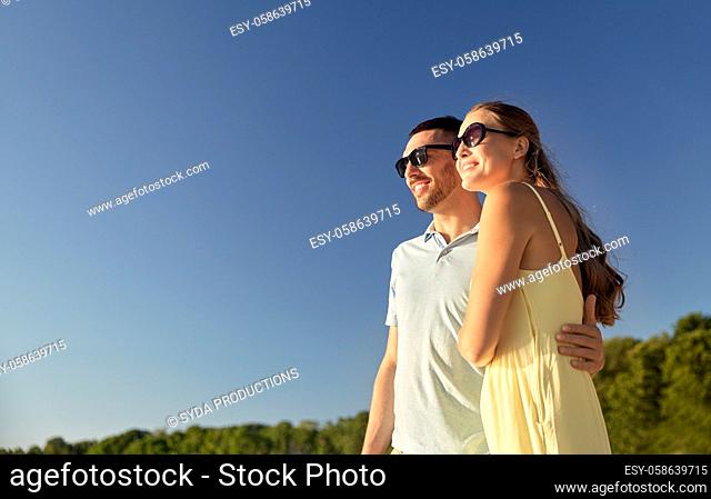 happy couple hugging outdoors in summer