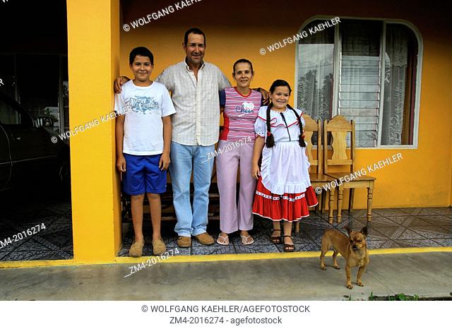 COSTA RICA, NEAR ARENAL, SMALL VILLAGE, FAMILY IN FRONT OF HOME