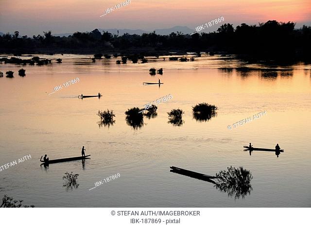 Sunset fishermen in boats on the Mekong River Muang Khong Si Phan Don Laos