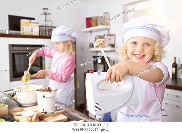 Germany, Girls making dough in kitchem