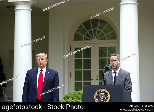 United States President Donald J. Trump, left, listens as Adam Boehler, CEO of U.S. International Development Finance Corporation