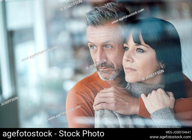 Thoughtful couple looking away at cafe