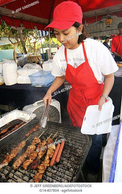 Community fair, Hispanic female food vendor. Festival of the Arts, North Beach, Miami Beach, Florida. USA