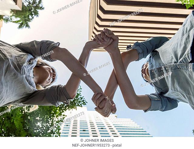 Low angle view of women holding arms