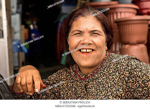 Betel nut addicted market trader laughing at the camera