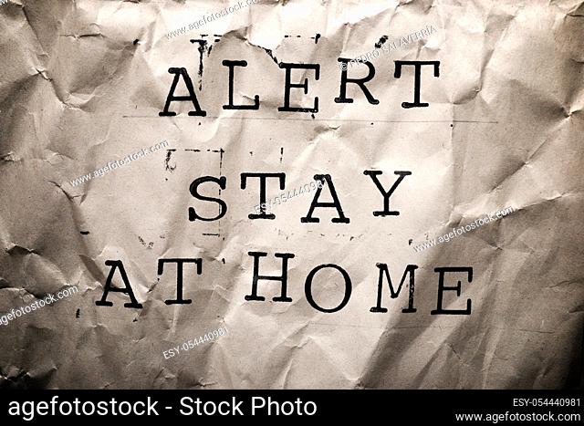 Alert Stay at Home text on a brown paper