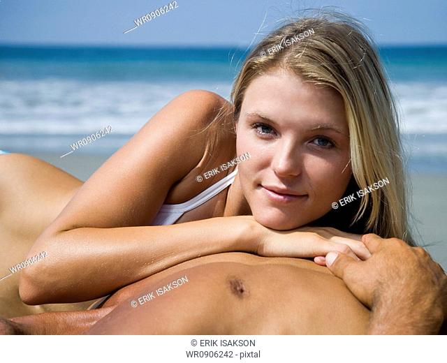 Portrait of a young woman resting her head on a young mans chest