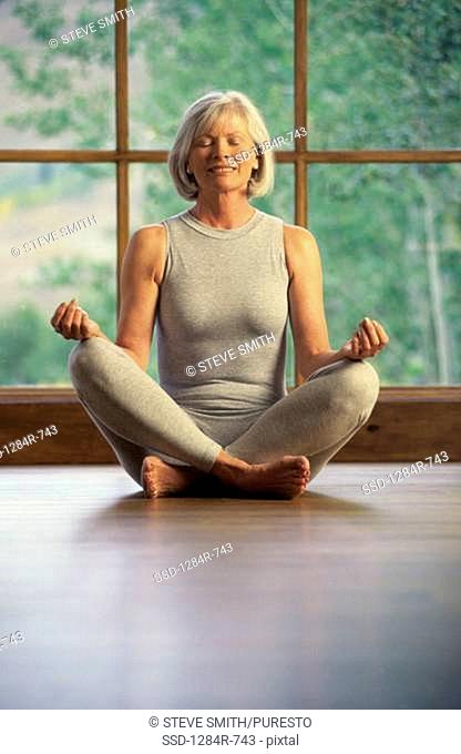 Senior woman meditating on the floor