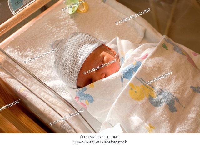 Newborn baby boy in hospital crib