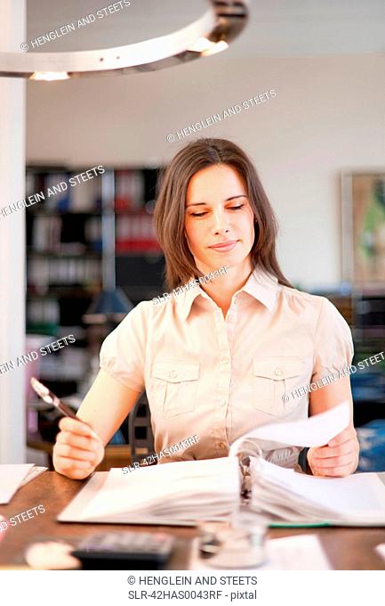 Businesswoman writing at desk