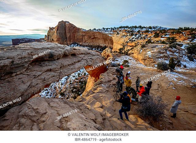 Tourists, photographers taking pictures of Mesa Arch at sunrise, view at Grand View Point Trail, Island in the Sky, Canyonlands National Park, Moab, Utah, USA