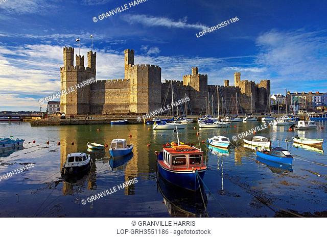 Wales, Gwynedd, Caernarfon. Boats moored by Caernarfon Castle at the mouth of the of the Seiont river