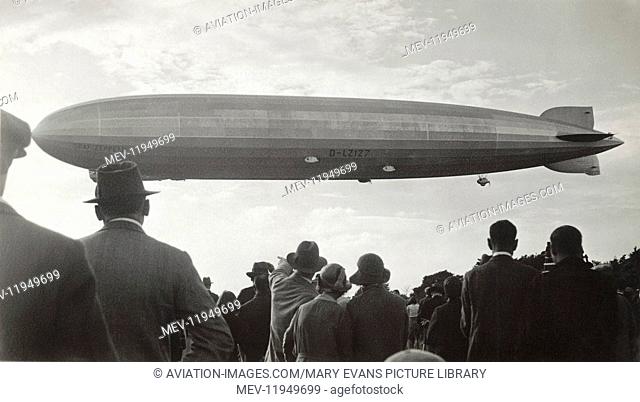 People Wearing Hats Watching the GRAF Zeppelin Flying