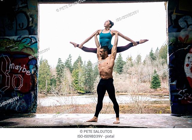 Couple practising acroyoga on outdoor stage