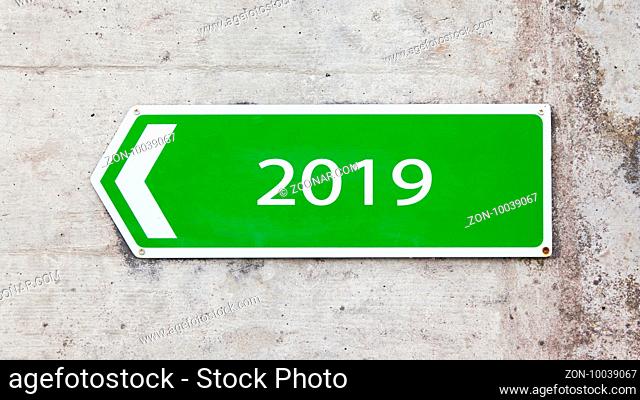 Green sign on a concrete wall - New year - 2019