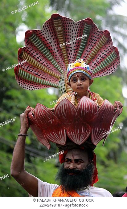 Dhaka 05 September 2015. An Bangladeshi child dressed as the Hindu god Lord Krishna wait in queue with his father at a temple on the occasion of 'Janmashtami'...
