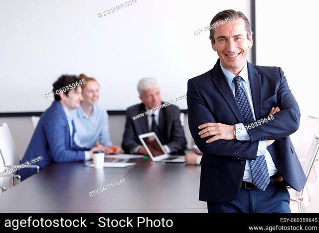 Portrait of an handsome businessman in front of his team in office