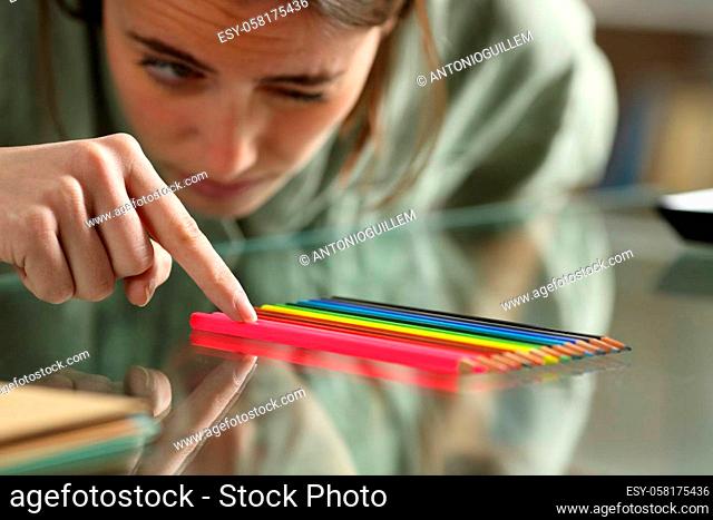 Obsessive compulsive woman aligning up pencils on a table