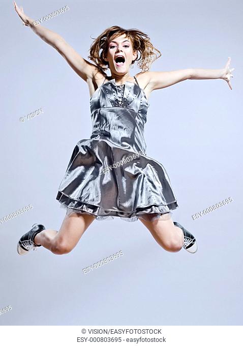 beautiful young caucasian woman girl evening dress jumping screaming happy on studio isolated plain background