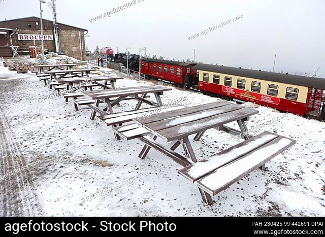 25 April 2023, Saxony-Anhalt, Schierke: View of snow-covered tables and benches on the Brocken. The summit of the Harz Mountains wrapped itself in fog today