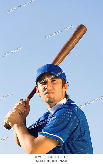 Baseball player swinging baseball bat low angle view