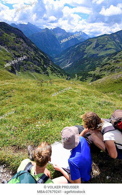 AllgÃ¤uer Alpen, AllgÃ¤u Alps, family group of hikers checking the hiking map, view into valley HÃ¶henbachtal, Lechtal Valley, Tyrol, Austria