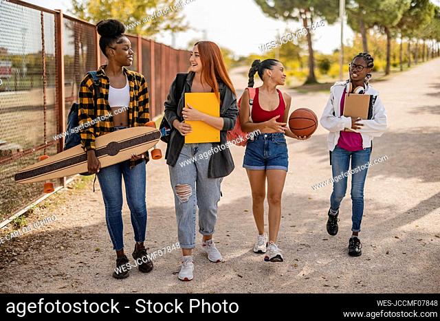 Young women walking together on road