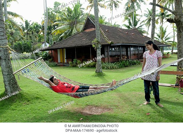 Couple at hammock in heritage lake resort ; Kuttanad ; Alleppey Alappuzha ; Kerala ; India MR777K;777L