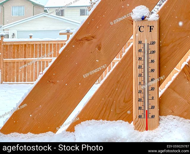 A Thermometer on a snow fall with a cold temperature