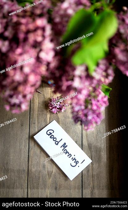Lilac flowers and good morning note on the rustic style background