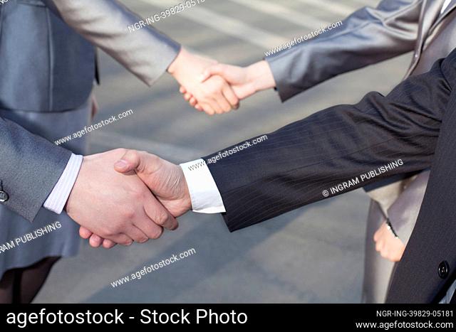 Close up of four business people shaking hands
