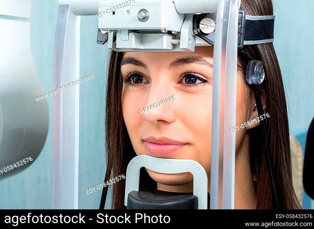 Close up face shot of girl with head positioned in cephalometric panorama x-ray machine