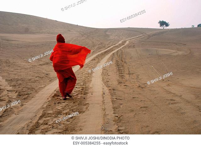Lady walking in desert of Khuri ; Jaisalmer ; Rajasthan ; India