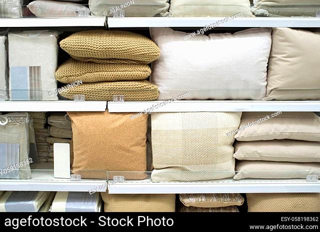 Bright pillows and bed wear on shelves. Selective focus