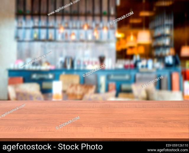 Dark wooden board empty table in front of blurred background. Perspective brown wood over blur in cafe interior - can be used for display or montage our...